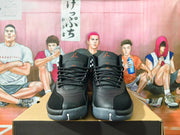 Front view of black high-top Jordan sneakers with orange tongue logos and grey outsole sections.
