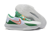 White basketball shoe with green and orange accents, shown with the patterned outsole.