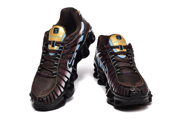 Pair of Nike Shox TL sneakers in dark brown, pale blue, black, and gold, shown from the front.
