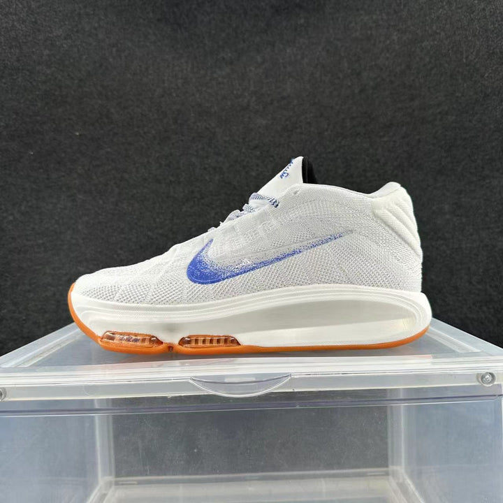 Side view of a white knit Nike sneaker with a blue Swoosh and orange outsole accents.