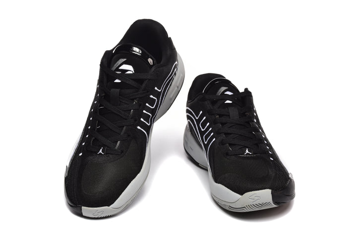 Pair of black and white Jordan basketball sneakers shown from the front and side.