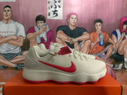 Side view of a white Nike sneaker showing the red Swoosh, textured upper, layered sole, and red outsole edge.