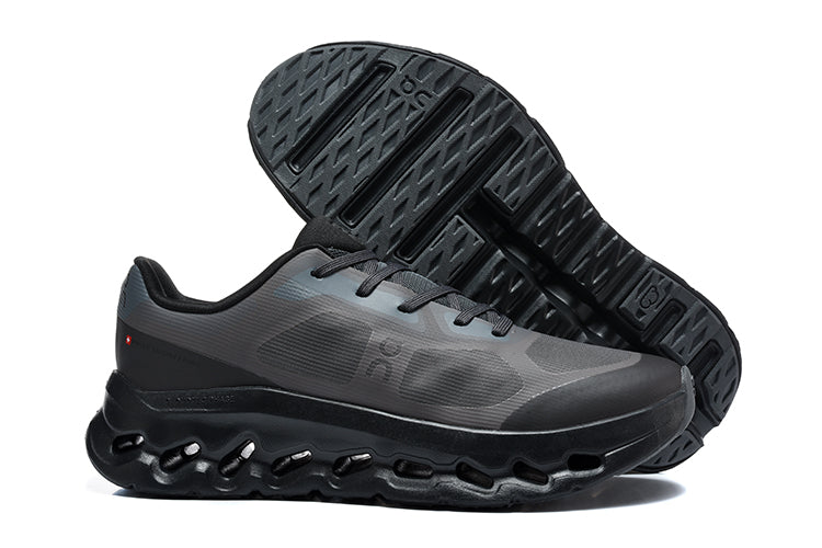 Dark charcoal and black On Cloudtilt Remix sneakers, with one shoe showing the patterned outsole.