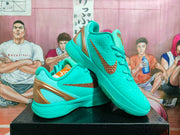Angled view of the turquoise sneakers with bronze side swooshes, heel detailing, and textured uppers.