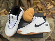 Pair of white and black high-top sneakers shown from the front and side on a black shoebox.