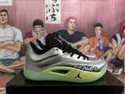 Side profile of a silver and black Jordan basketball sneaker with a patterned panel, Jumpman logo, and visible Air Zoom marking.