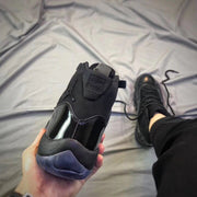 Rear view of a black high-top sneaker showing the padded collar and translucent heel outsole.