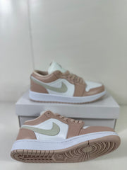 Pair of Jordan Air Jordan 1 Low sneakers in white and light bone, shown with one shoe on top of the box.