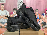 Angled view of black Nike sneakers showing the lace-up construction, side swoosh, glossy overlays, and oval textured sole details.