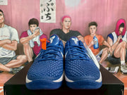 Front view of blue Nike basketball sneakers with textured uppers, blue laces, white Swoosh details, and white midsole sections.