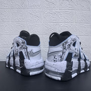 Rear view of the black and white sneakers with panda graphics and visible midsole cushioning windows.