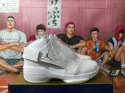 Side view of a white high-top shoe with a wide ankle strap, Jumpman side logo, and perforated details.