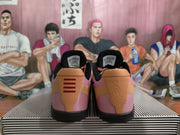 Rear view of the Nike basketball sneakers showing tan heel panels, pink upper sections, black collars, and red heel detailing.