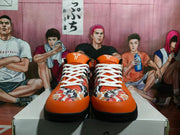 Front view of the orange and black Nike basketball sneakers with white laces and multicolor graphic toe panels.