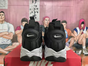 Rear view of black sneakers with heel pull loops and white midsole details.