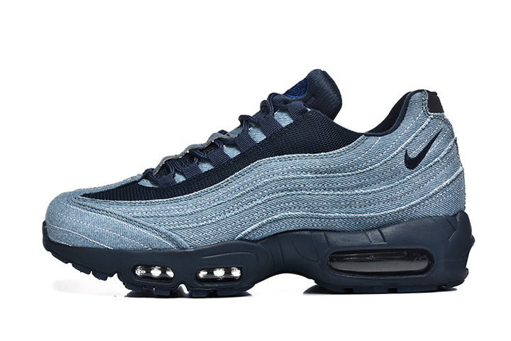 Side view of blue denim-style Nike Air Max 95 sneakers with dark laces and visible cushioning windows