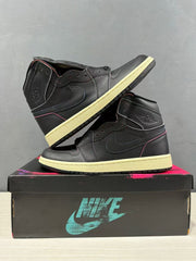 Pair of black high-top sneakers arranged on a branded shoe box, showing the outer sides and ankle details.
