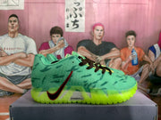 Side view of a green basketball sneaker showing the black-and-red Swoosh, black laces, textured upper, and lime outsole.