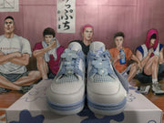 Front view of white and blue sneakers showing mesh panels, blue laces, and flower-shaped lace decorations.