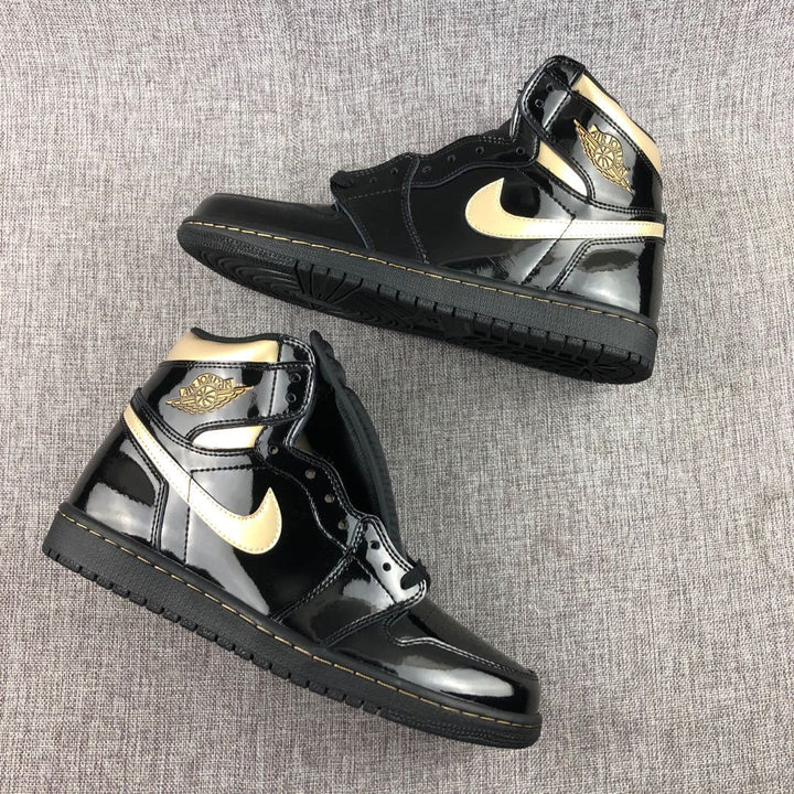 Pair of black and gold high-top Jordan sneakers shown from the side.