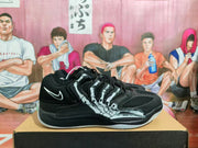 Side view of a black Nike basketball sneaker showing layered panels, graphic side detailing, and a white Swoosh.