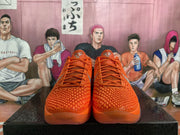 Front view of orange lace-up basketball shoes with textured uppers.