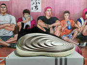 Close side view of the sculpted silver upper and cream-colored sole.