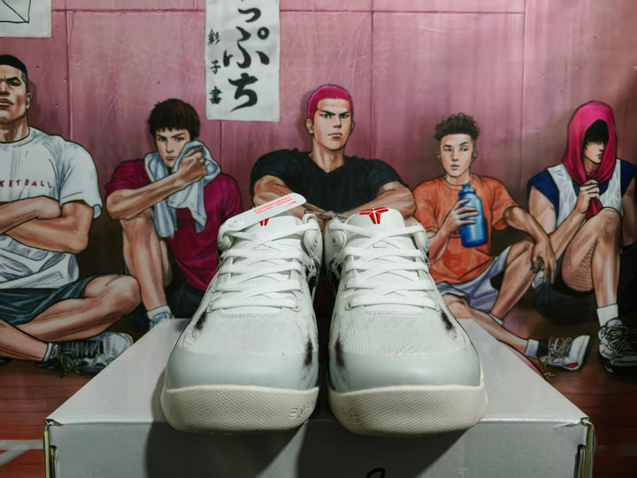 Front view of white Nike sneakers with red tongue logos, black detailing, and a basketball-themed illustrated backdrop.