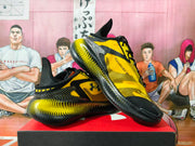 Angled view of the pair displaying the Under Armour logo, “MANSORY” text, and yellow-black dotted sole pattern.