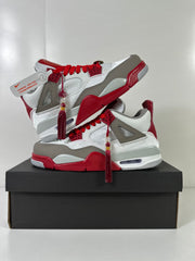 Two Jordan Dub Zero sneakers arranged on a black box, showing their contrasting red, white, gray, and black details.
