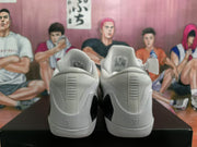 Rear view of a pair of white Nike basketball sneakers showing padded collars, heel detailing, and black heel sections.
