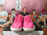 Front view of the pink sneakers showing tonal laces, textured toe areas, and white midsoles.