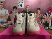 Front view of Jordan sneakers showing cream laces, tongue branding, textured side panels, and pink outsoles.