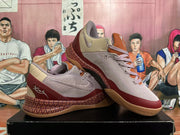 Angled view of mauve and burgundy Nike Kobe basketball shoes with visible logos