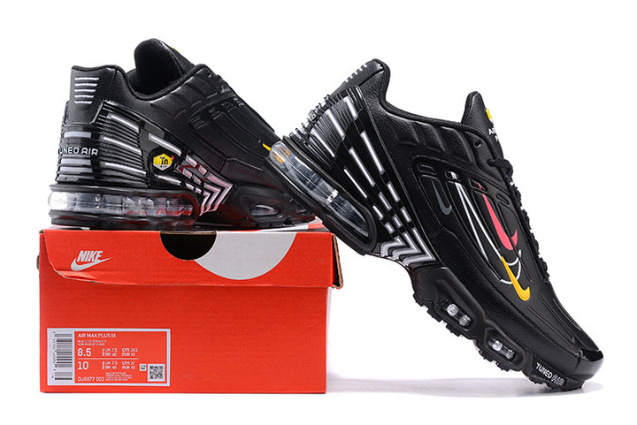 Black Nike Air Max Plus sneakers with colorful side accents displayed on a Nike shoebox; box label shows sample size US Men 9.5 and US Women 11.