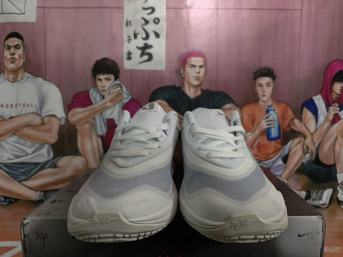 Front view of white and silver Nike A'ja basketball sneakers displayed on a shoe box.
