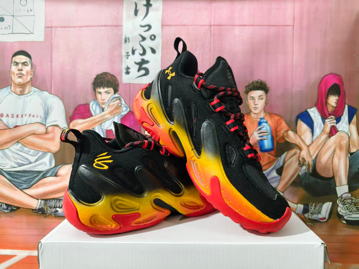 Pair of black Under Armour basketball shoes with yellow-to-red gradient accents and patterned laces