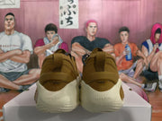 Rear view of gold-brown sneakers showing heel pull tabs, off-white heel cushioning, and sculpted outsole details.
