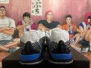 Rear view of white basketball shoes with black leopard-patterned heel panels and blue heel accents.