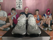 Front view of white and black Nike basketball shoes with striped uppers and lace-up fronts.