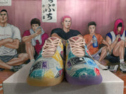 Front view of multicolor Monopoly-themed Nike basketball shoes with pale pink laces and contrasting colored outsoles.