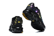 Nike Air Max Plus sneakers shown from the heel and outsole, with black soles and yellow outsole accents.