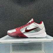 Side view of a silver and wine-red Nike basketball sneaker with wine-red laces and a white midsole.