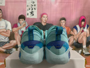 Rear view showing blue heel details and pull tabs on the pale aqua shoes