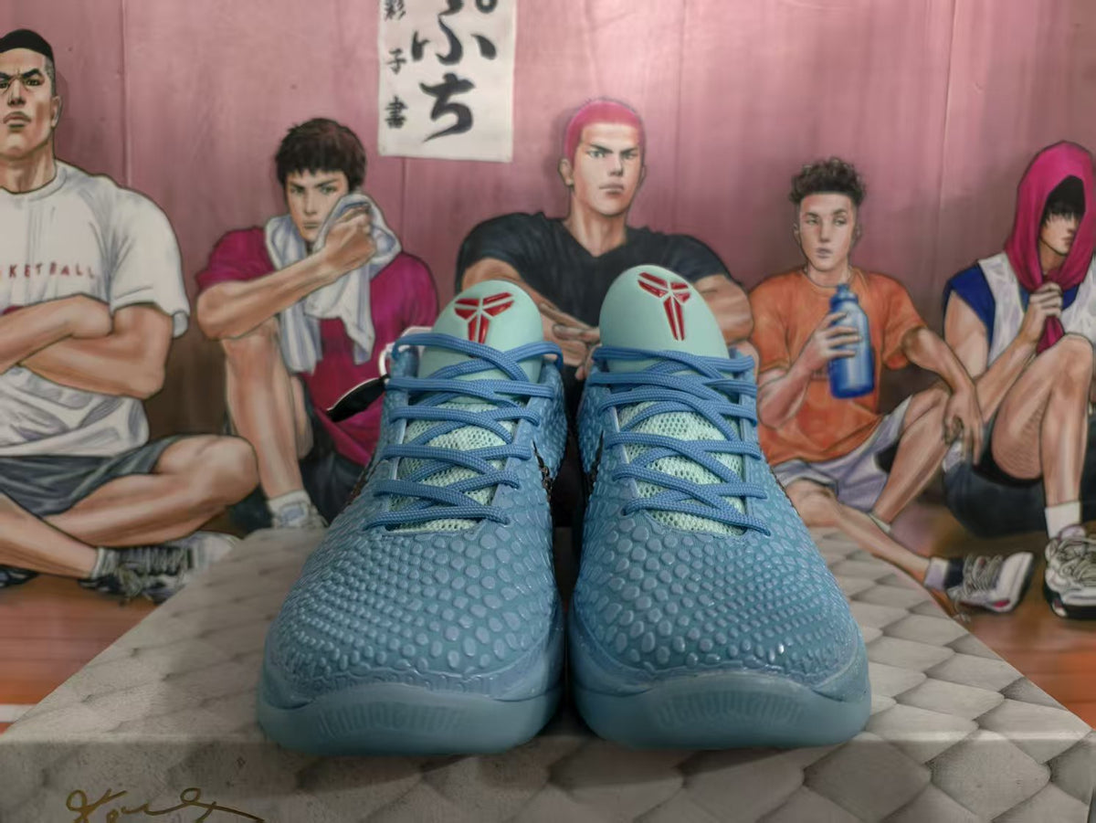 Front view of blue basketball sneakers with textured uppers, blue laces, and red tongue graphics.