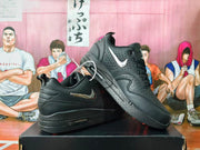 Pair of black Nike low-top sneakers showing perforated panels and metallic-look Swooshes