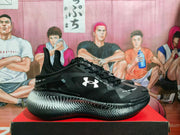 Side profile showing the Under Armour logo, black upper, and silver dotted gradient midsole.
