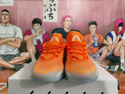Front view showing orange laces, tongue details, and gray translucent outsoles.