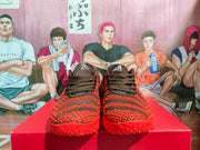 Front view of black and red Nike basketball sneakers displayed on a red box.