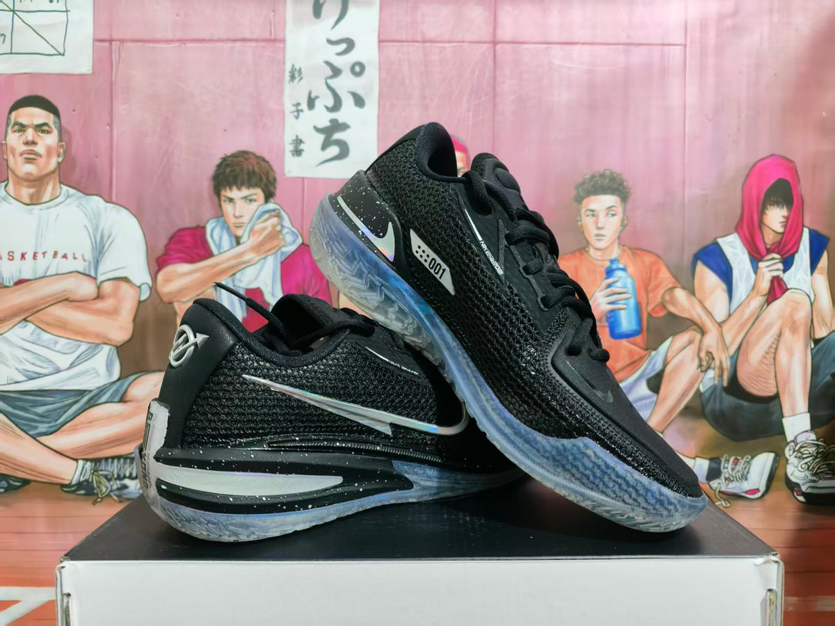 Pair of black Nike basketball sneakers displayed at an angle on a shoebox, showing textured uppers, reflective-style side branding, and translucent soles.